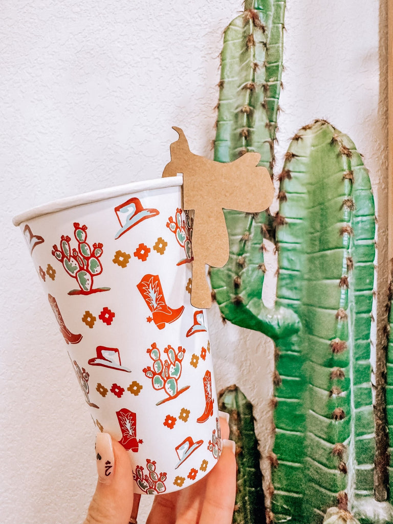 saddle shaped drink tag on vintage western paper cup. cactus background for decoration.