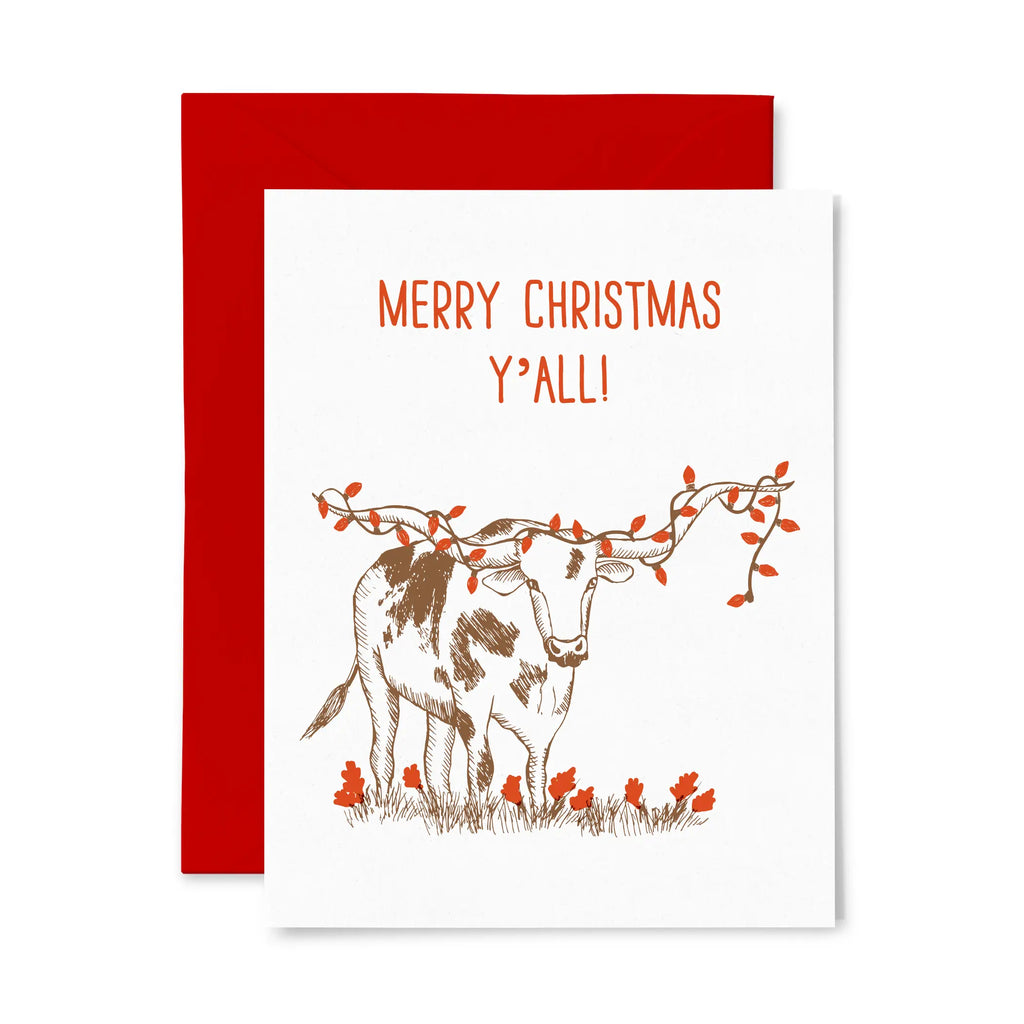 White card with "Merry Christmas Y'all" text. Brown and white longhorn with red Christmas lights wrapped around the longhorns 