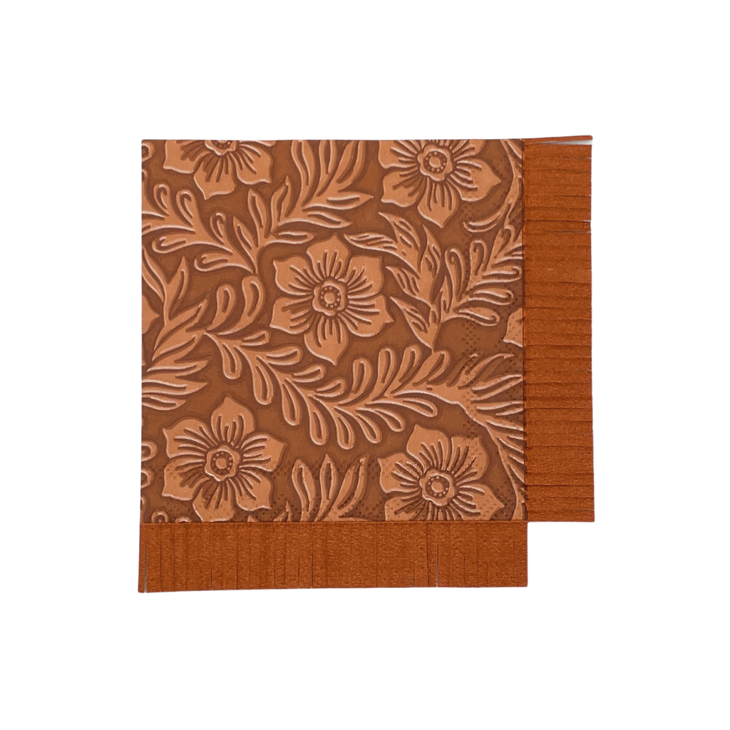 Light brown floral tooled leather print on a square, brown, paper cocktail napkin with brown fringe cut on two sides