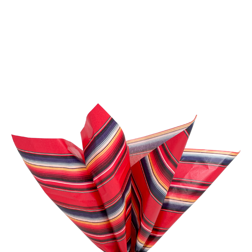 Tissue paper with red serape print. Colors are blue, red, yellow, white stripes. Black grosgrain ribbon handle
